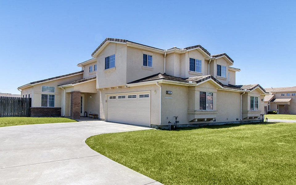 a white house with a garage and a lawn