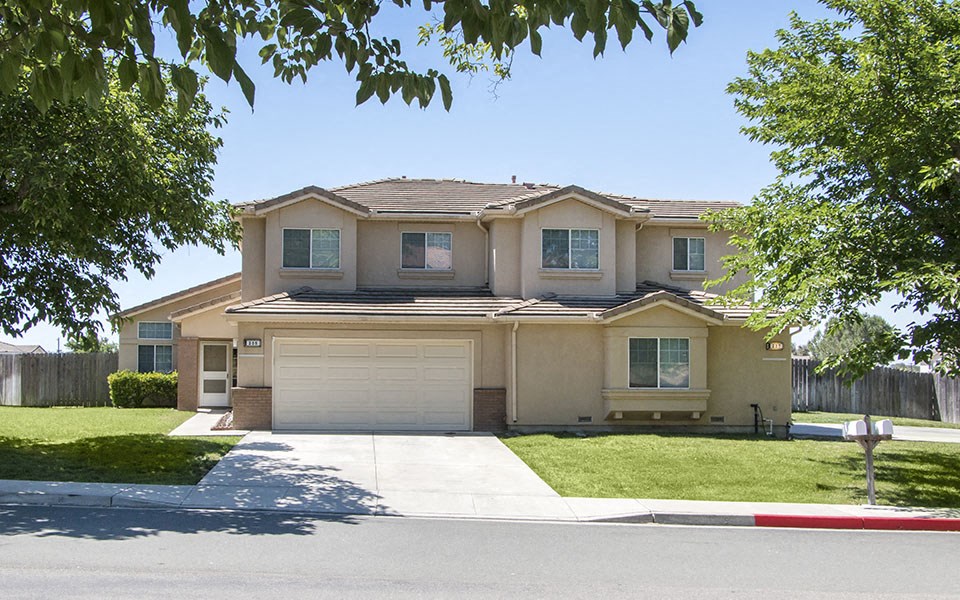 a house with a garage door and a lawn