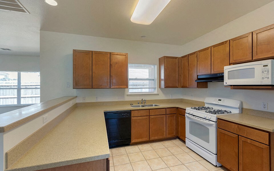 an empty kitchen with a stove microwave and sink
