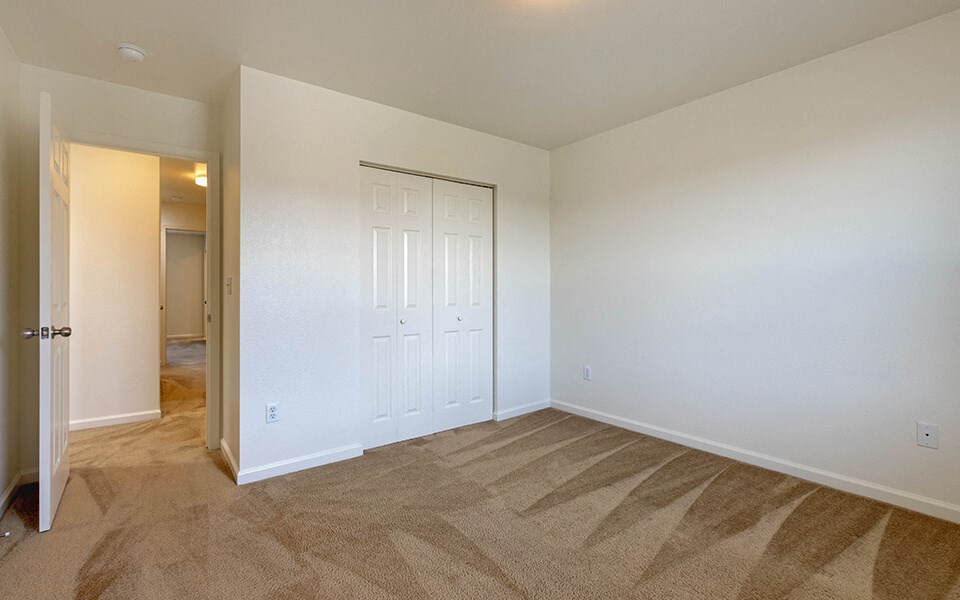 a bedroom with a closet and a door to a bathroom