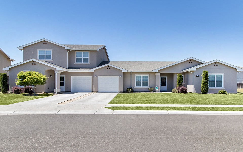 a house with a driveway and lawn in front of it
