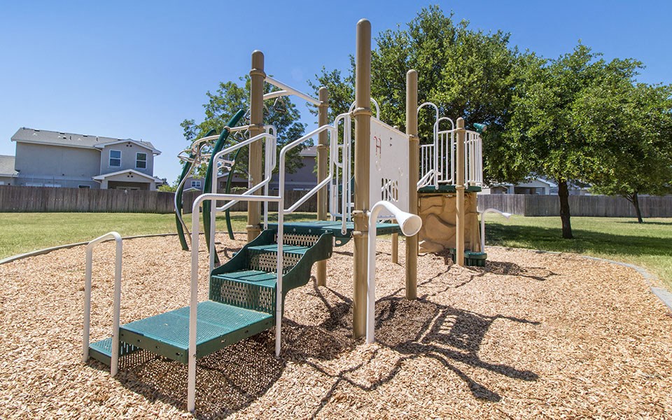 a playground with a slide and stairs in a park