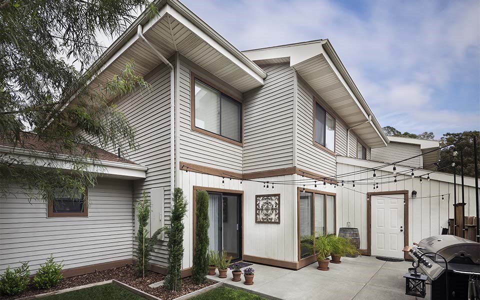 a white house with a driveway and a patio