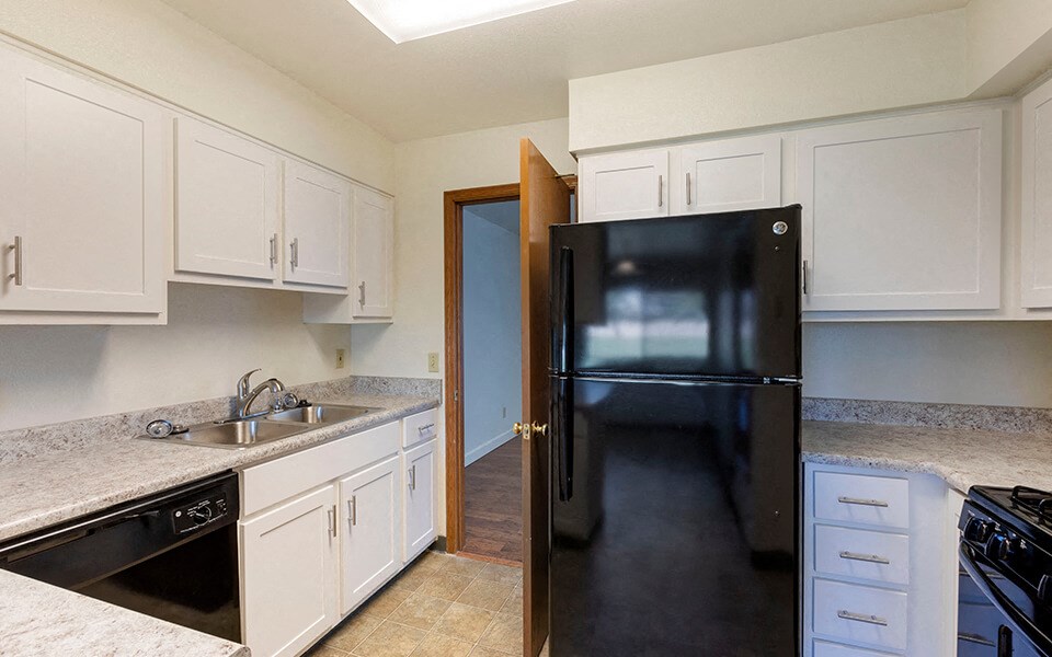 a kitchen with black appliances and white cabinets