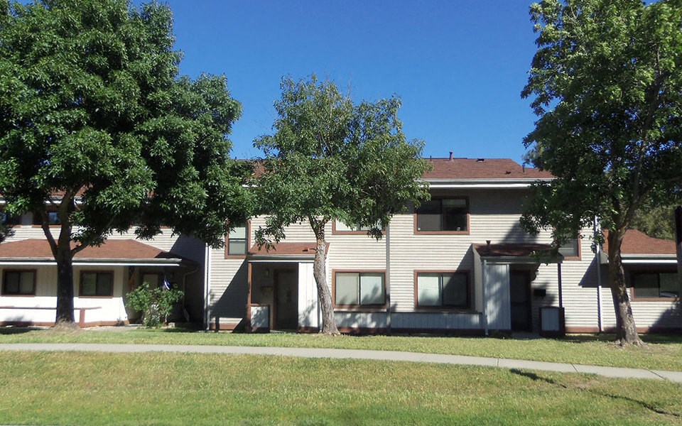 an apartment building with trees in front of it
