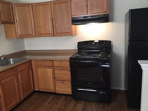 a kitchen with black appliances and wooden cabinets