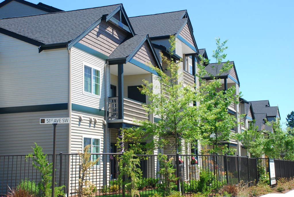 a house with a fence and trees in front of it