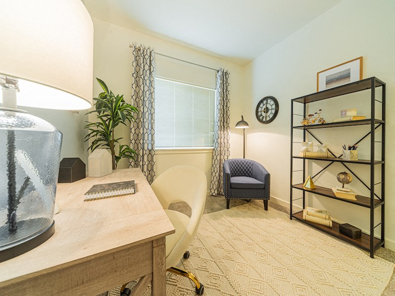 a home office with a desk and chair and a clock on the wall