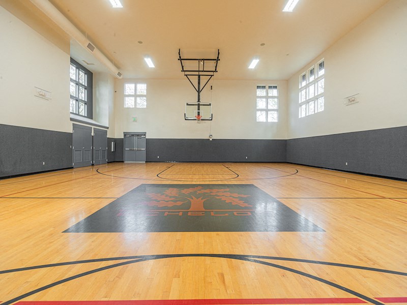 the inside of an empty gym with a basketball court and wood floors