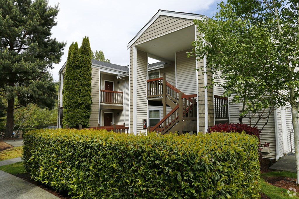 the front of a house with a hedge in front of it
