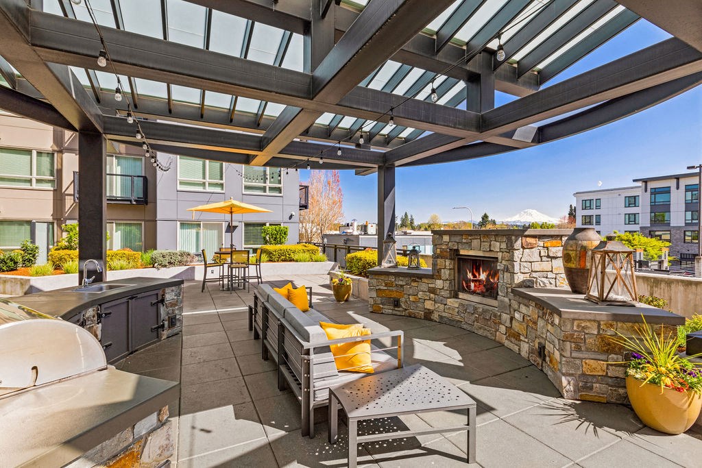 a patio with a stone fireplace and outdoor furniture