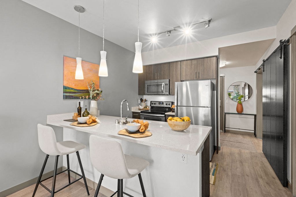 kitchen with stainless steel appliances and island with white quartz counter tops