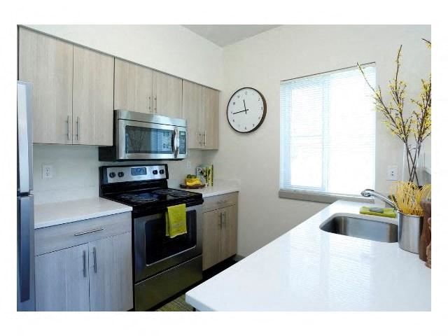 a kitchen with stainless steel appliances and a clock on the wall