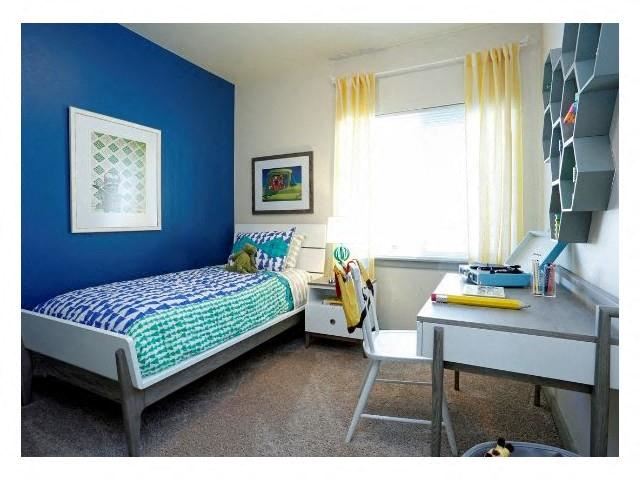 a small bedroom with a bed and a desk
