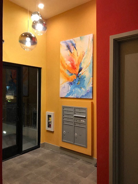 a hallway with a painting on the wall and a door