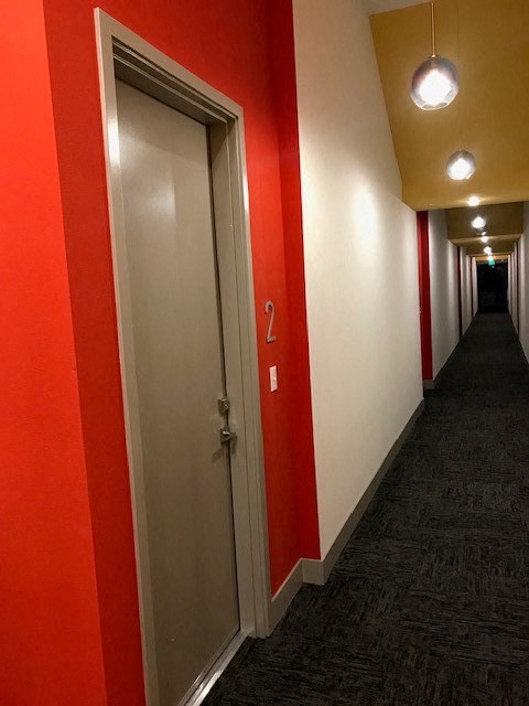a hallway with red and white walls and a door