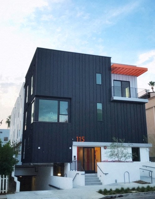 the exterior of a house with black siding