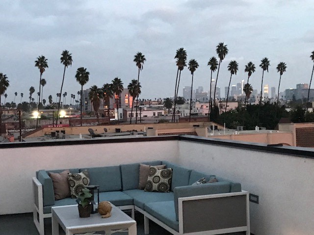 a balcony with a couch and a view of palm trees