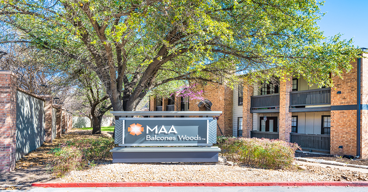 A sign for MAA Balcones Woods is in front of a building.