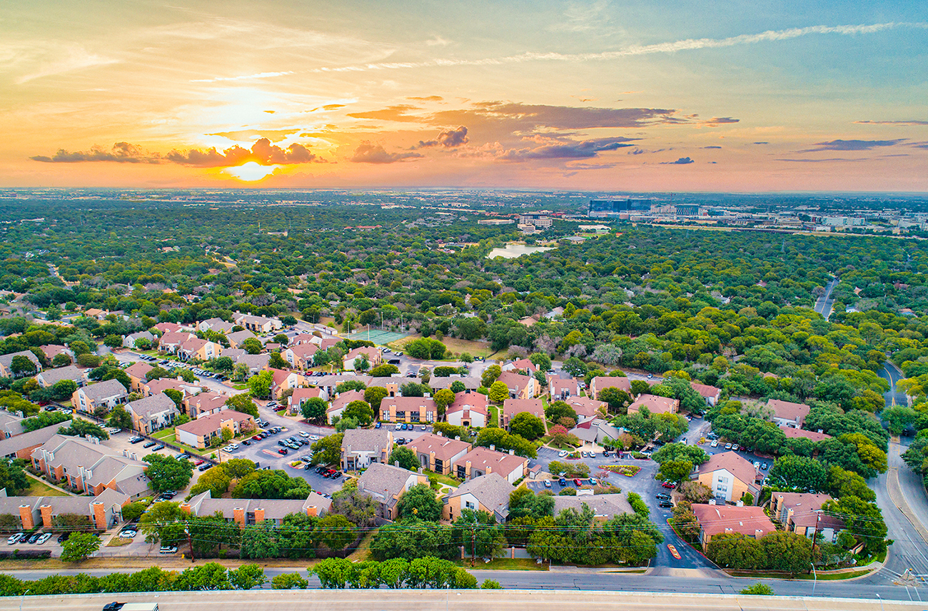 an aerial view of a suburban neighbourhood with a sunset