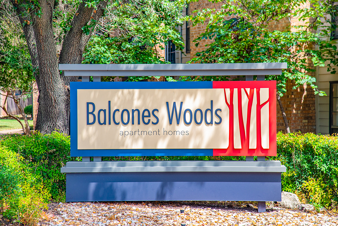 a sign for bachelors woods apartment homes in front of trees