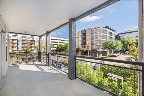 a balcony with a view of a city street and buildings