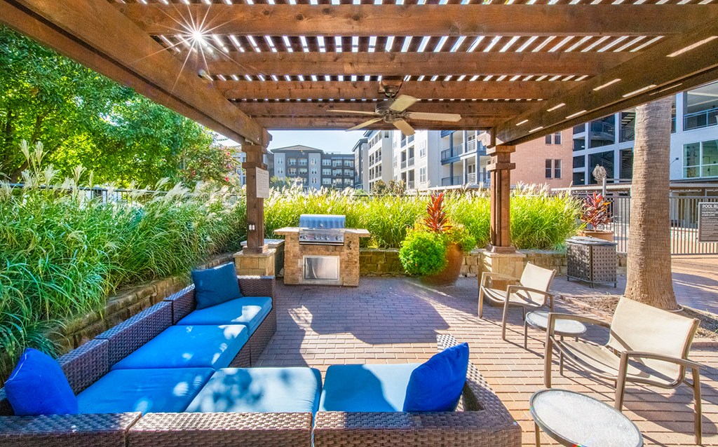 a covered patio with couches and chairs and a fire pit