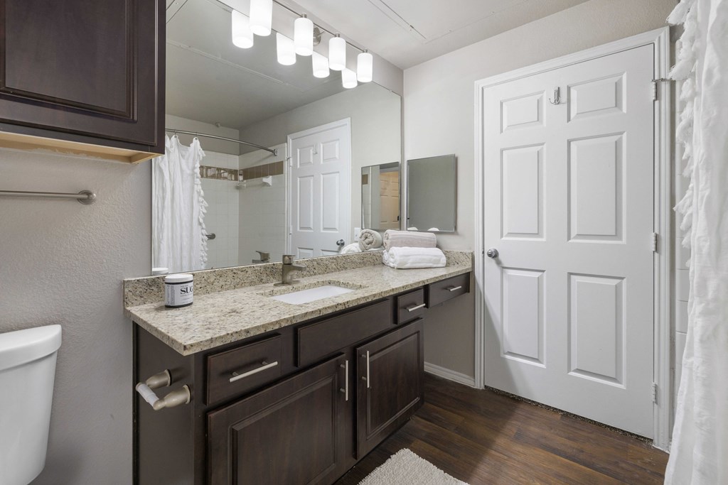 A bathroom with a white towel hanging on the door.