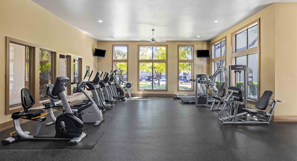 A gym with treadmills, exercise bikes, and weights.