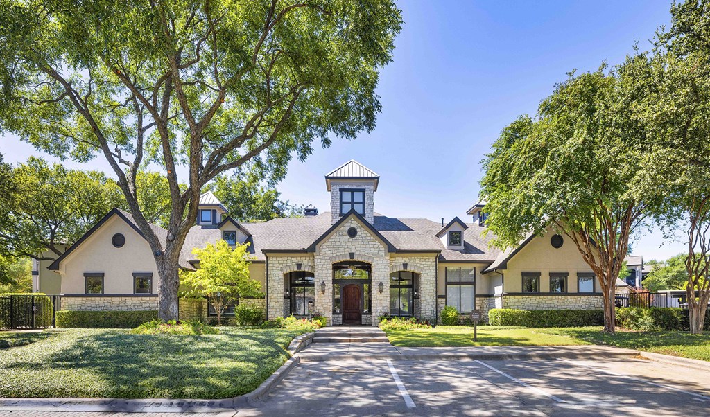 A house with a driveway and trees in front.