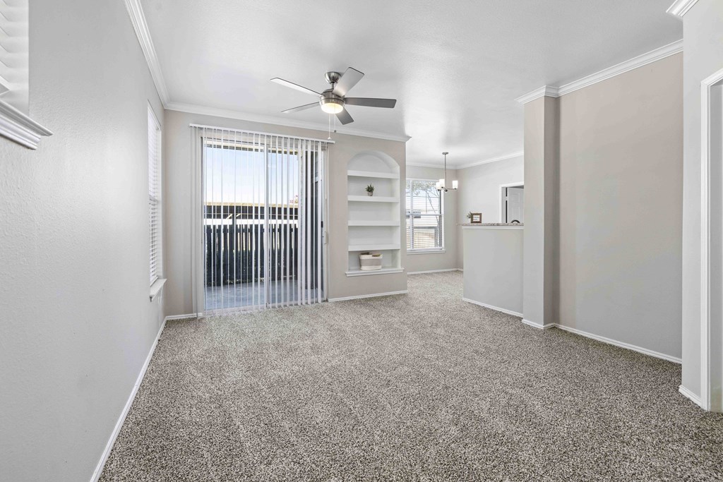 A room with a ceiling fan and a window with blinds.