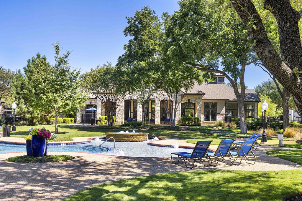 A house with a pool and a tree in front.