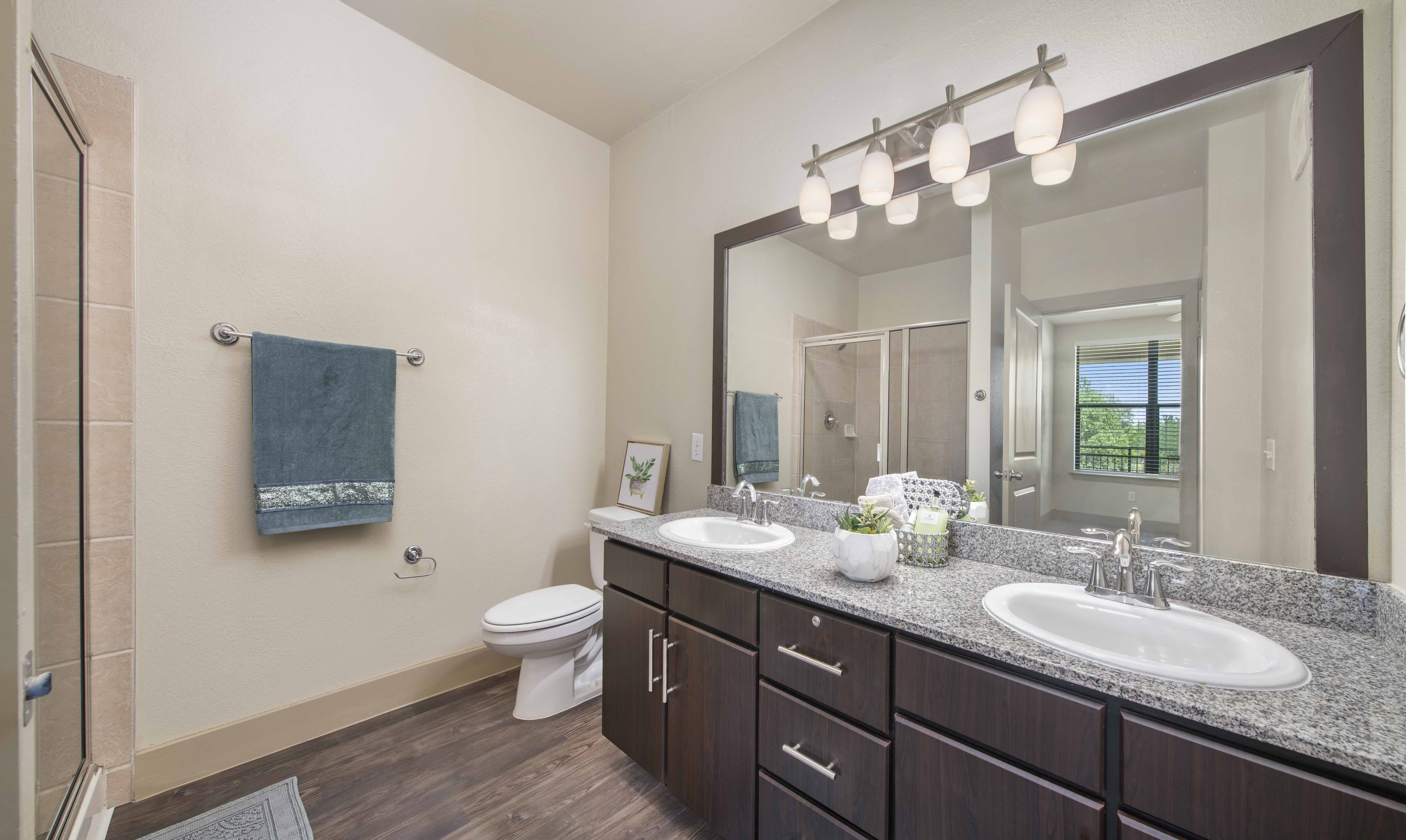 a bathroom with two sinks and a toilet and a large mirror