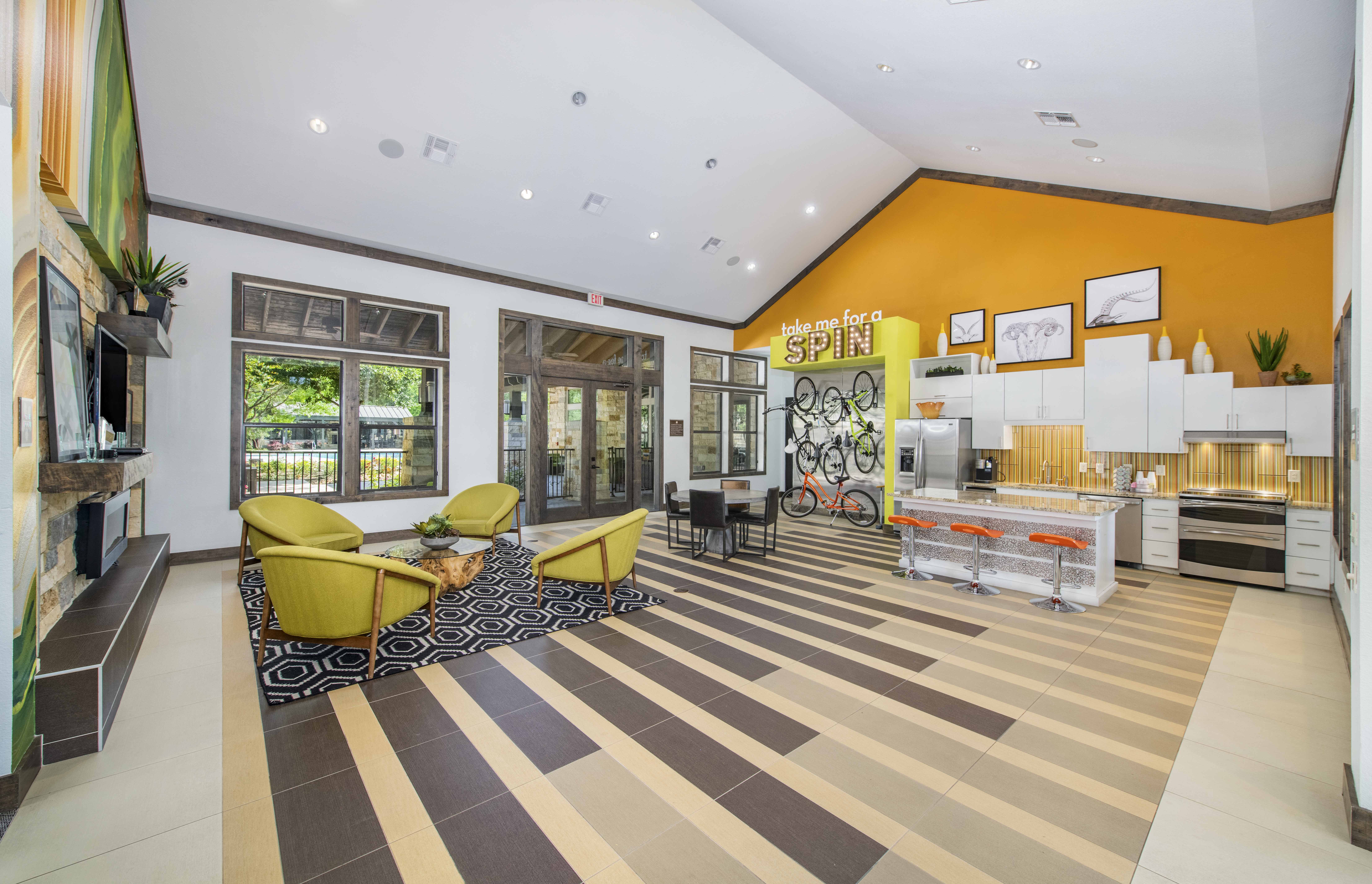 the lobby of a condo with yellow chairs and a striped rug