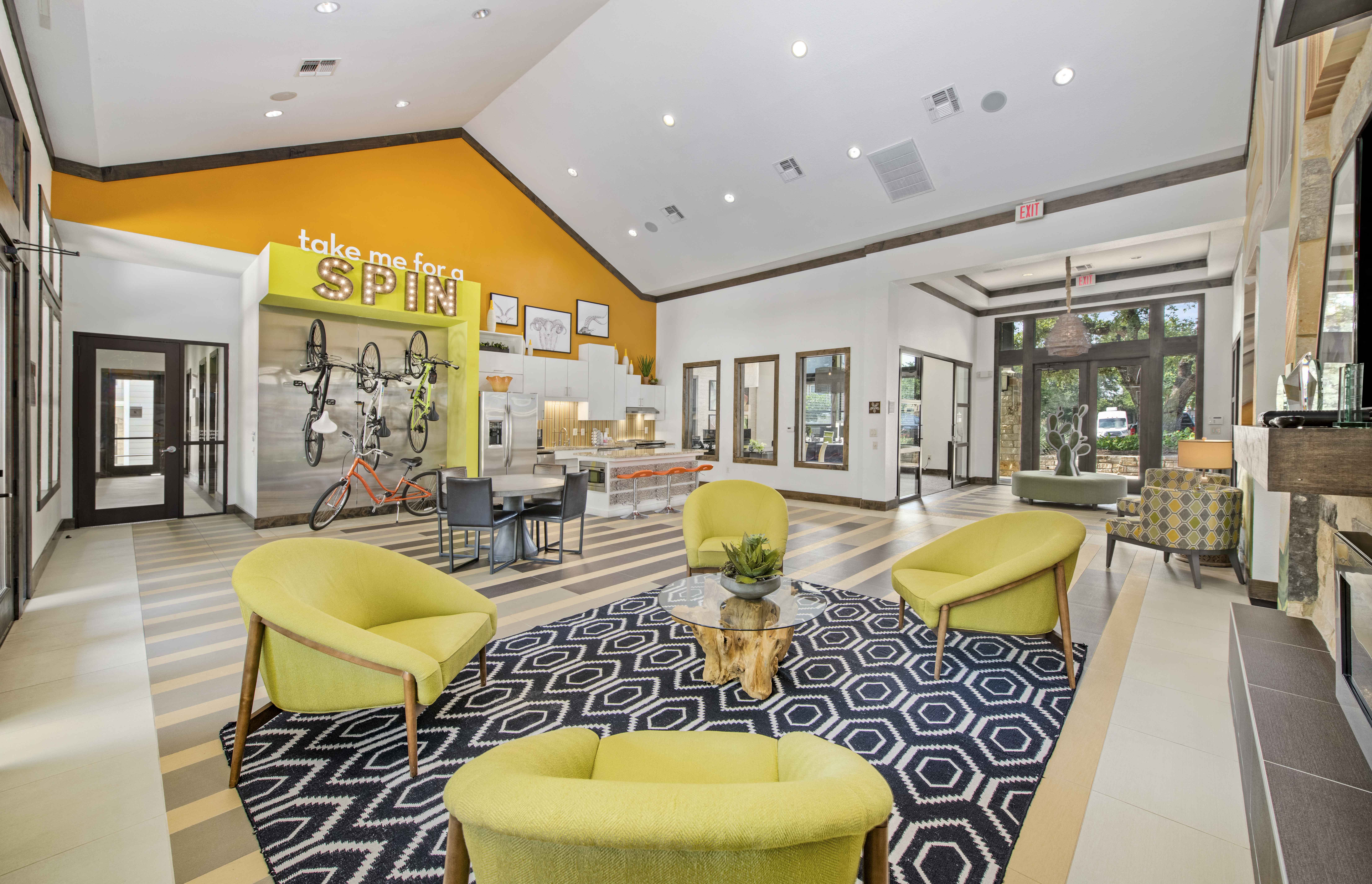 a lobby with yellow couches and chairs and a yellow sign on the wall