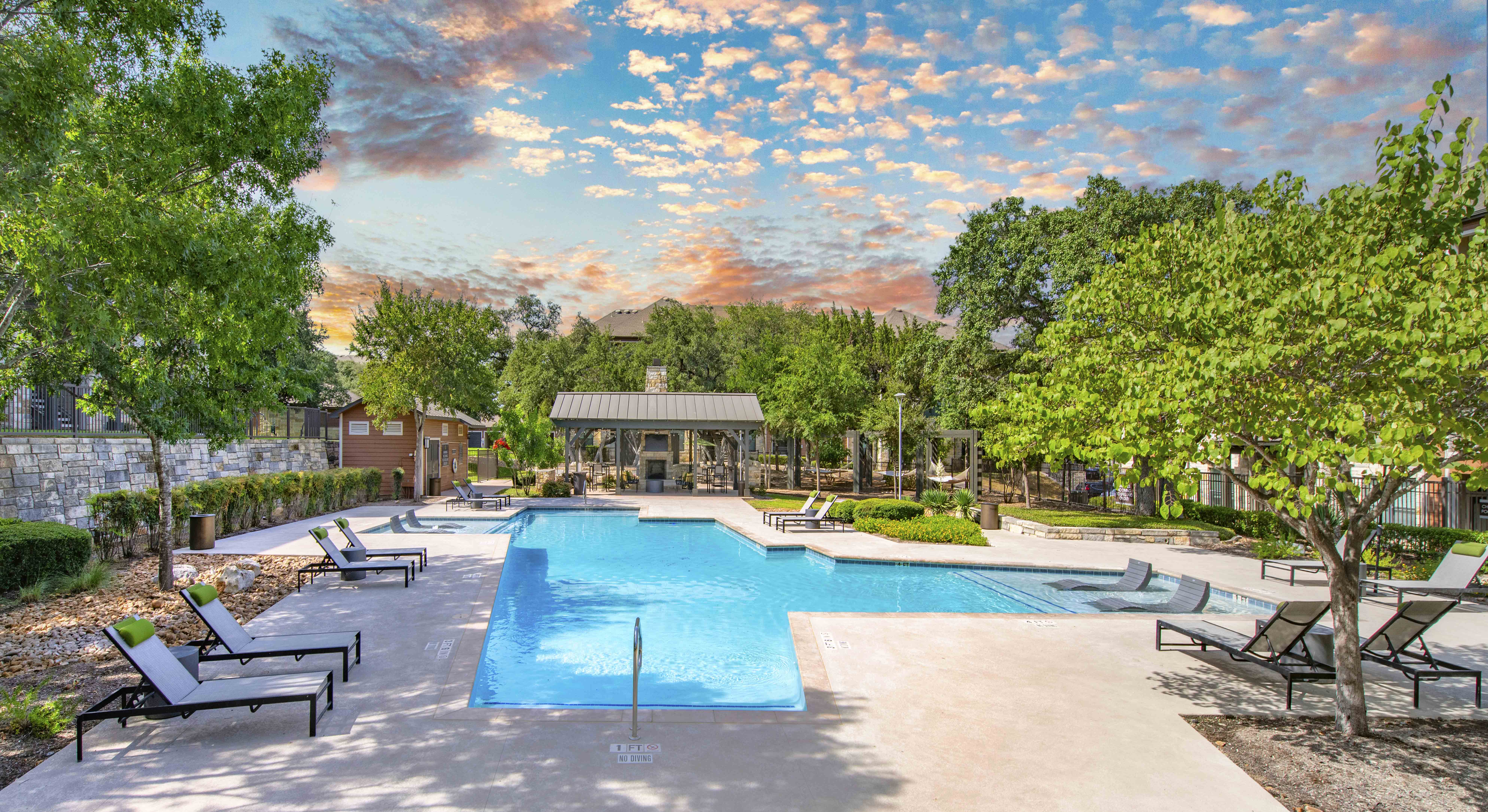 a swimming pool with trees and chairs around it