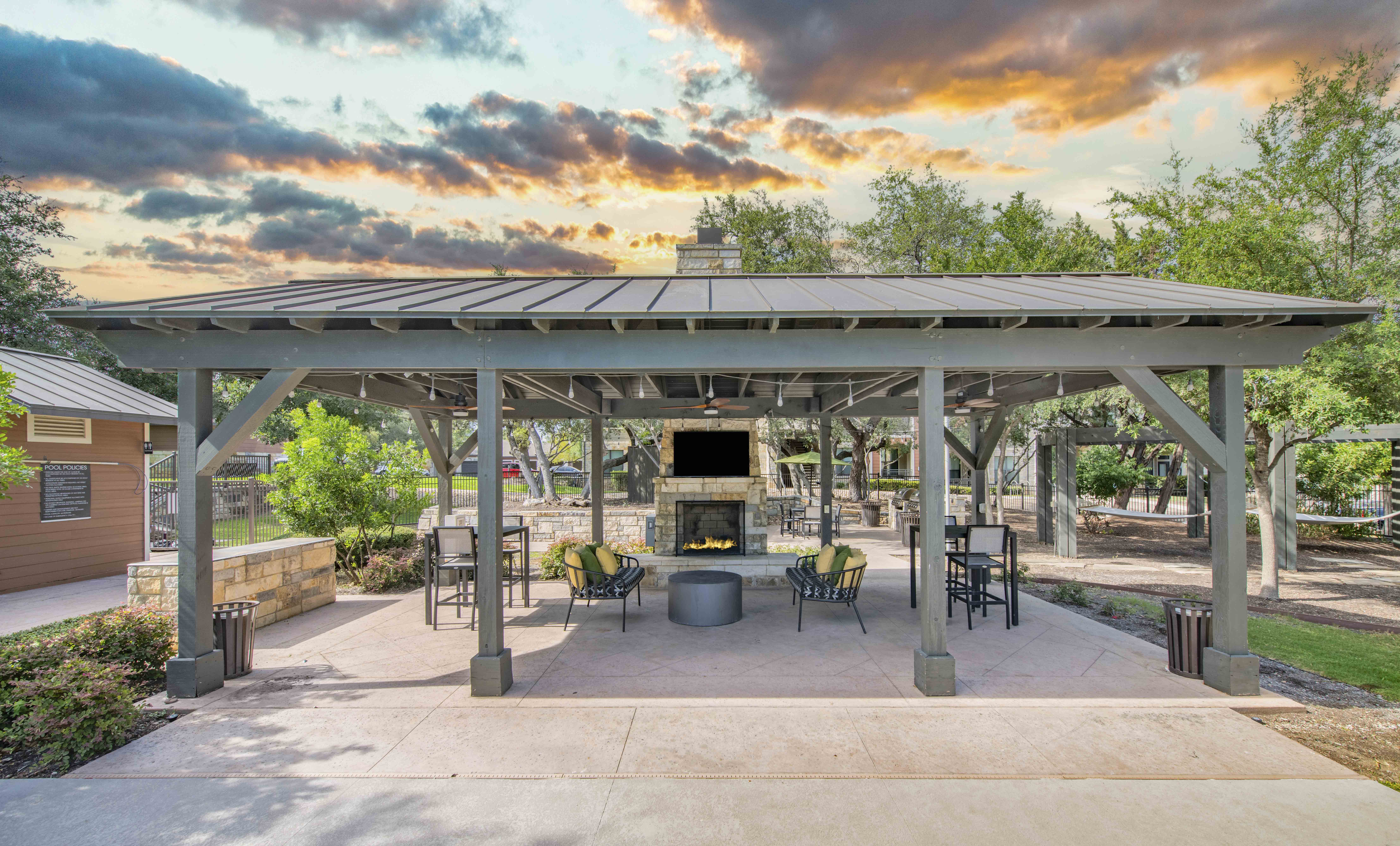 a patio with a fireplace and a pavilion