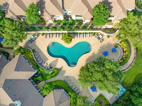 an overhead view of an outdoor swimming pool with umbrellas