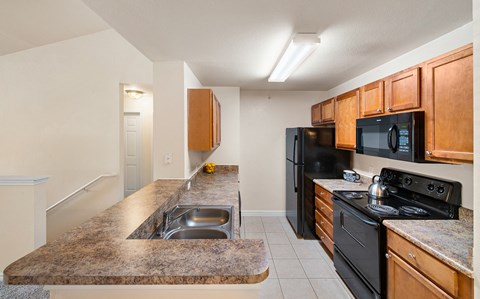 a kitchen with black appliances and granite counter tops