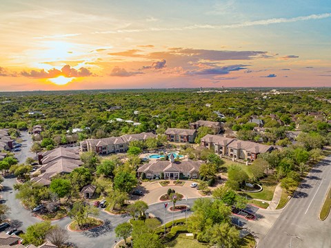 an aerial view of a neighborhood of houses at sunset