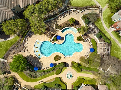 an overhead view of an outdoor swimming pool with a resort style pool