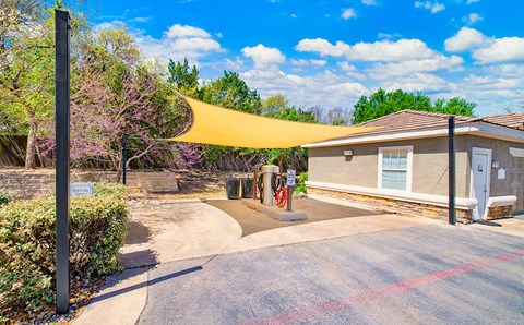 the yard of a house with a canopy over the driveway
