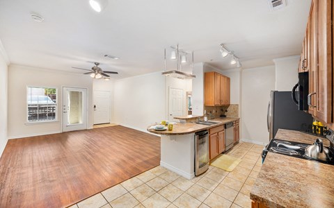 a kitchen and living room with a counter top and a refrigerator