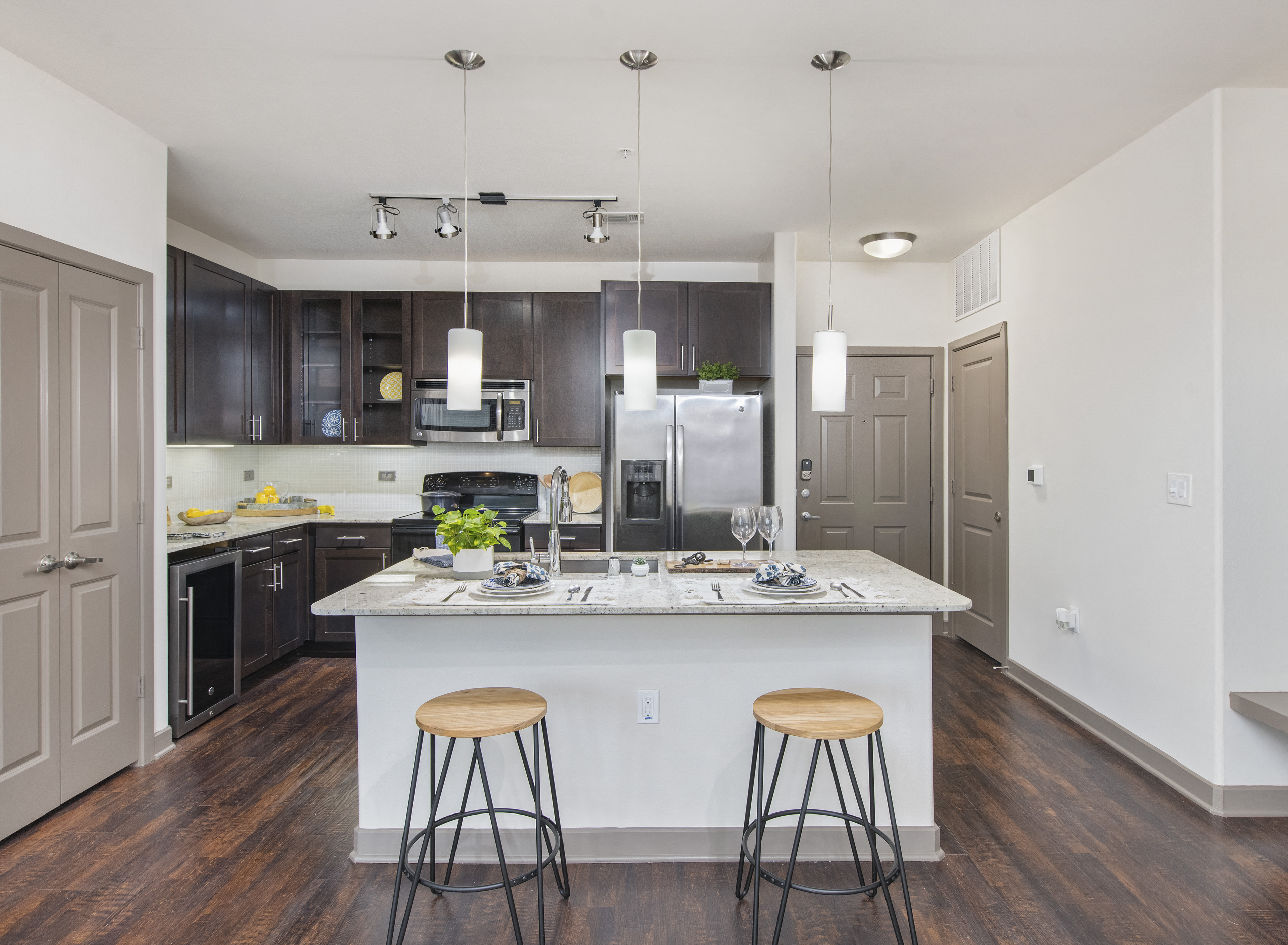 a kitchen with a large island with three stools