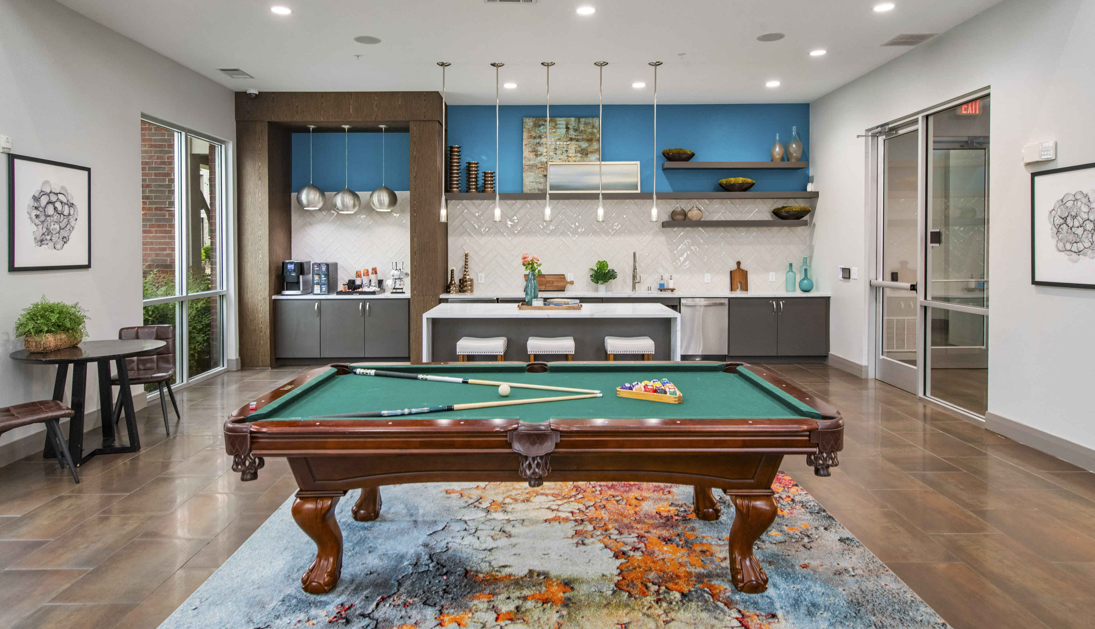a pool table in a living room with a kitchen