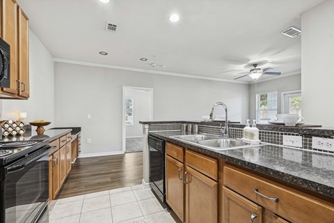 A kitchen with black appliances and wooden cabinets.