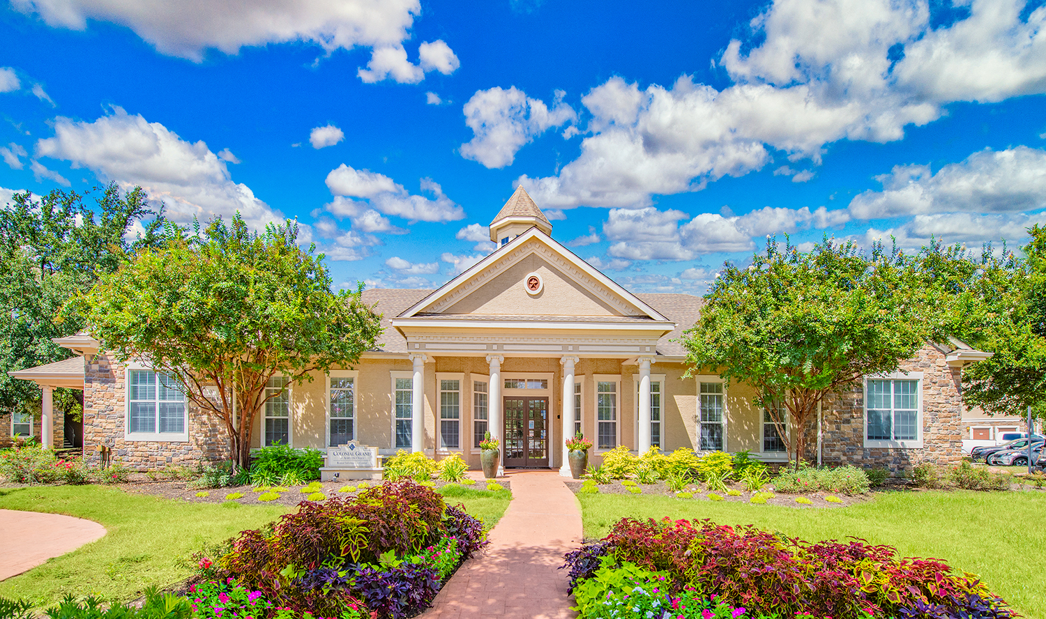 the front of a house with a lawn and trees