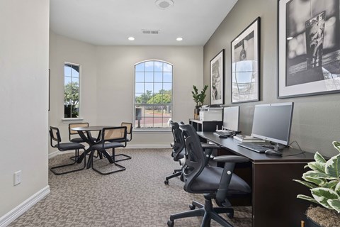an office with desks and chairs and a window