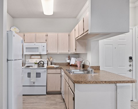 a kitchen with white appliances and a granite counter top
