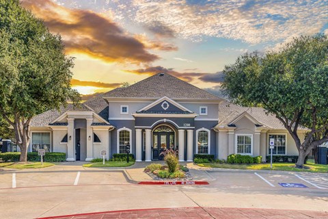 the front of a house with a driveway and trees